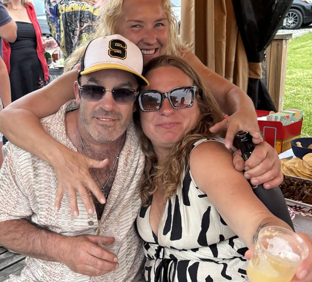 Friends gathered for a selfie at a dockside party