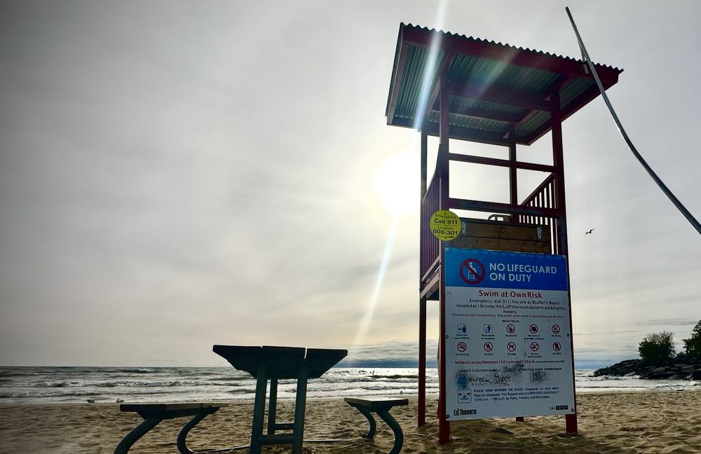 Lifeguard chair and beach safety sign on the shore