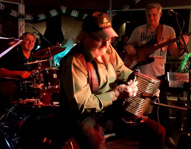 A band performing on stage under red light