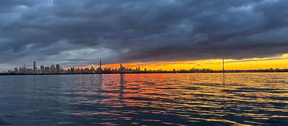 The Toronto skyline at sunset under dark clouds