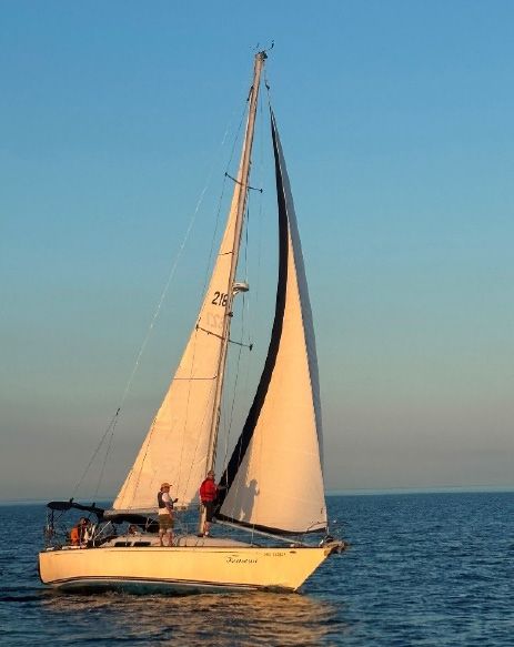 A sailboat at sunset on open water