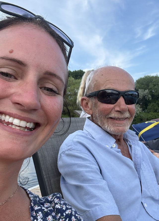 Two members smiling for a selfie on a boat